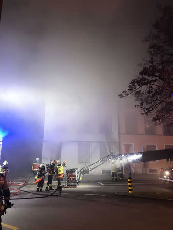 Firefighters are seen in front of a house where six people were killed in an apartment fire early on Monday morning, police said, while an unspecified number of others caught in the blaze were taken to the hospital in Solothurn, Switzerland November 26, 2018. Polizei Kanton Solothurn/Handout via REUTERS.