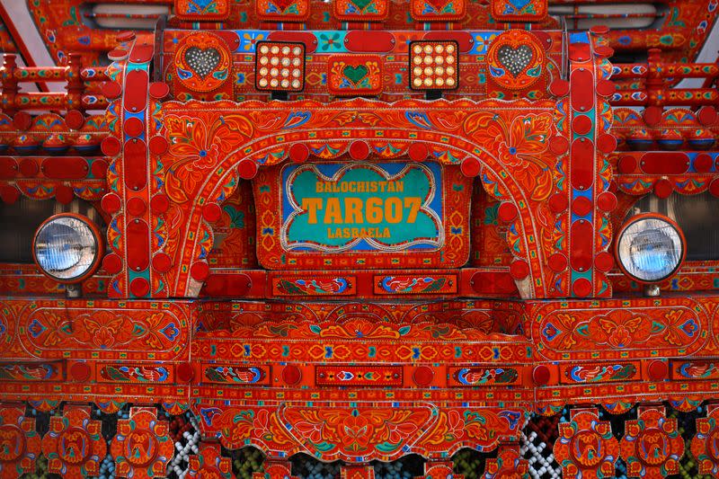 A close-up view of a truck decorated with colours at a workshop in Peshawar