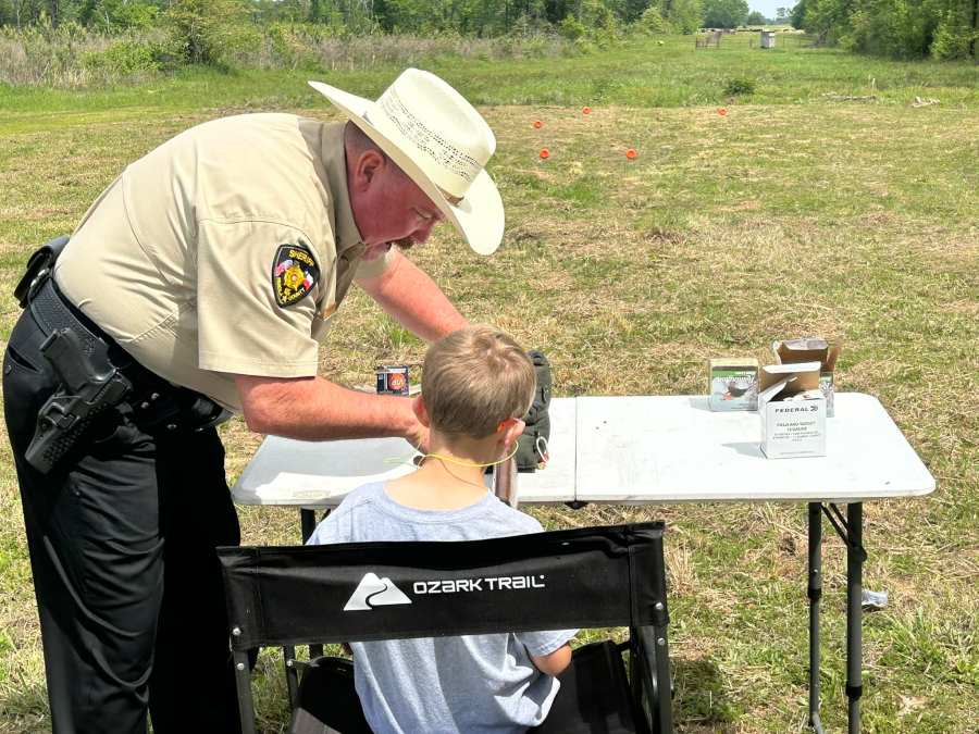 A member of Panola County Sheriff’s Office teaches a child about shotgun safety. Photo courtesy of Panola County Sheriff’s Office.