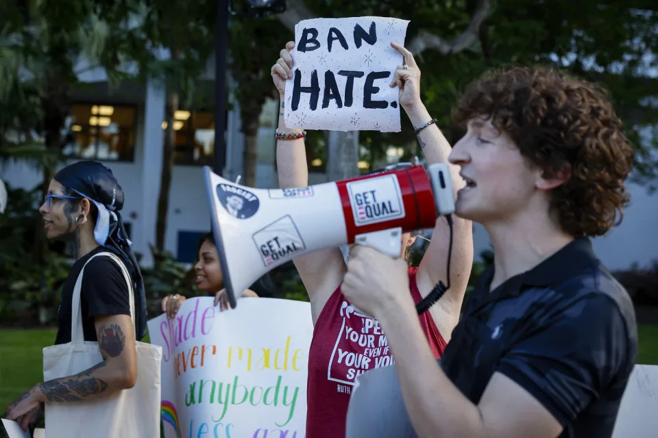 A demonstrator holds a placard reading 