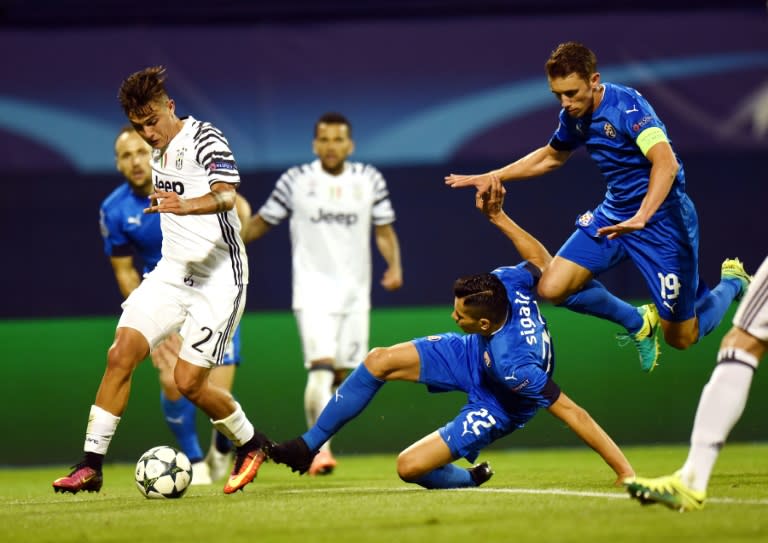 Juventus' Paulo Dybala (L) fights for the ball with Dinamo's Leonardo Sigali (C) and Josip Pivaric during their UEFA Champions League Group H match, at the Maksimir stadium in Zagreb, on September 27, 2016