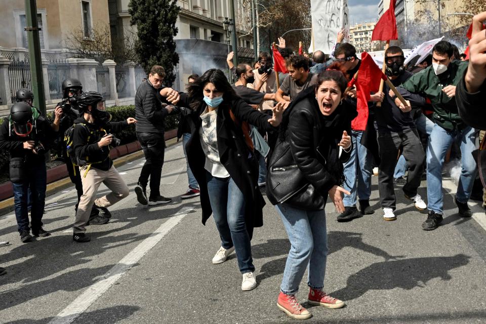 Protesters shout towards gas-throwing riot police during a massive demonstration in Athens on March 5, 2023, following the deadly train accident late on February 28. - The toll from Greece's worst rail accident rose to 57 victims after a head-on collision blamed on "human error", that has sparked angry protests.