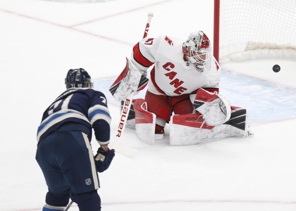 Columbus Blue Jackets forward Nick Foligno, left, scores past Carolina Hurricanes goalie James Reimer during the second period of an NHL hockey game in Columbus, Ohio, Sunday, Feb. 7, 2021. (AP Photo/Paul Vernon)