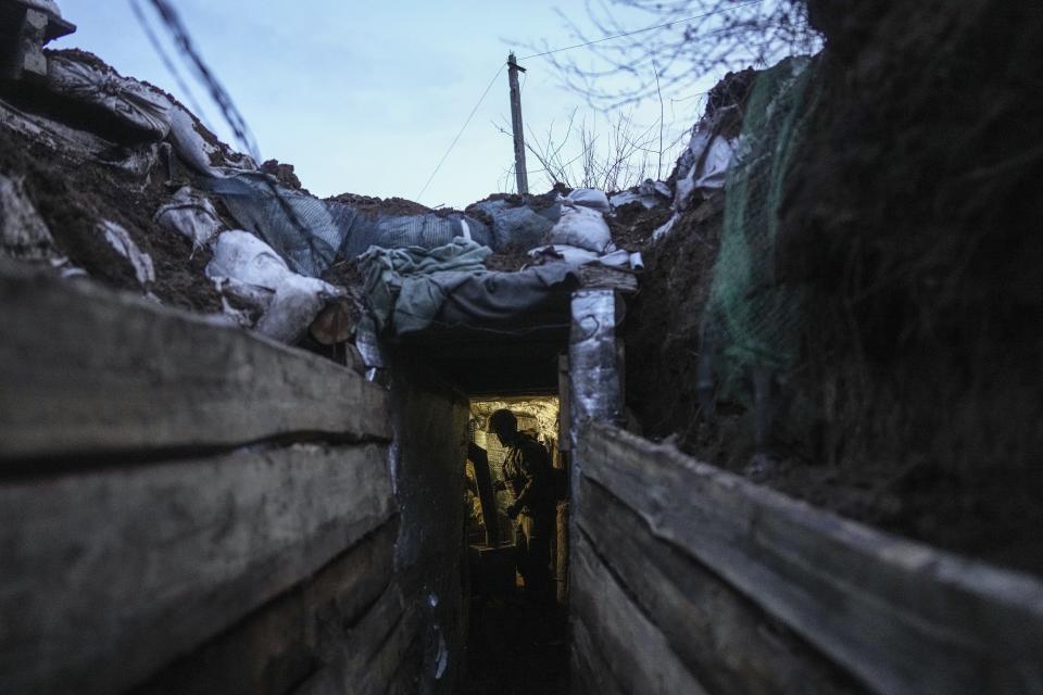 A Ukrainian serviceman stands in a shelter on a position at the line of separation between Ukraine-held territory and rebel-held territory near Zolote, Ukraine, Saturday, Feb. 19, 2022. Ukrainian President Volodymyr Zelenskyy, facing a sharp spike in violence in and around territory held by Russia-backed rebels and increasingly dire warnings that Russia plans to invade, has called for Russian President Vladimir Putin to meet him and seek a resolution to the crisis. (AP Photo/Evgeniy Maloletka)