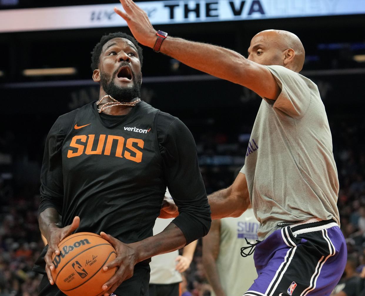 Phoenix Suns center Deandre Ayton drives to the basket past assistant coach Michael Ruffin as the team holds an open practice for fans at the Footprint Center on Saturday, Oct. 1, 2022. 