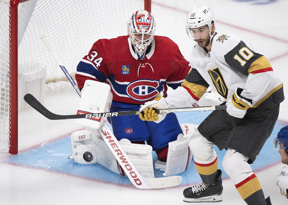 Vegas Golden Knights' Nicolas Roy and Montreal Canadiens goaltender Jake Allen watch the puck during the second period of an NHL hockey game Saturday, Nov. 5, 2022, in Montreal. (Graham Hughes/The Canadian Press via AP)