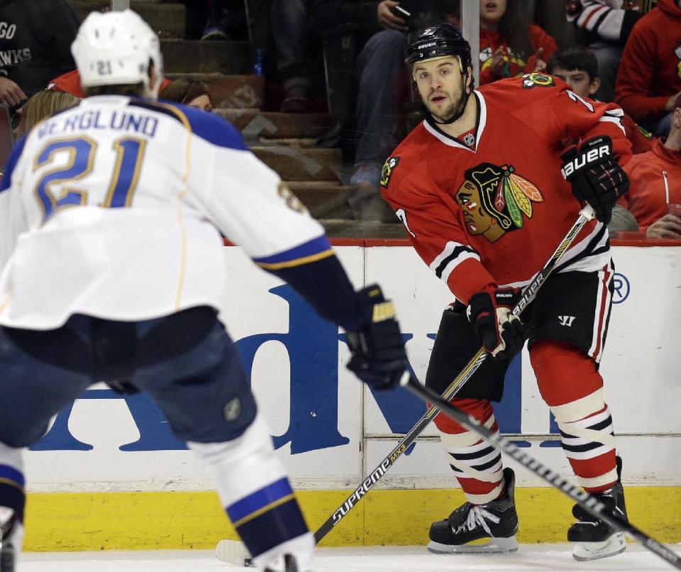 Chicago Blackhawks' Brent Seabrook, right, looks to a pass against St. Louis Blues' Patrik Berglund (21) during the first period in Game 6 of a first-round NHL hockey playoff series in Chicago, Sunday, April 27, 2014. (AP Photo/Nam Y. Huh)