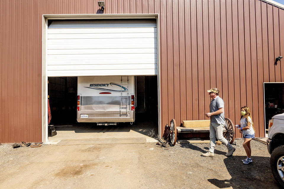 Woody and Luna Faircloth get a first look at a donated RV before delivering it to a Dixie Fire victim, Sunday, Sept. 5, 2021, in Sierra County, Calif. (AP Photo/Noah Berger)