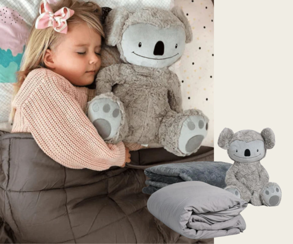 Girl sleeps with a koala toy and weighted blanket over her