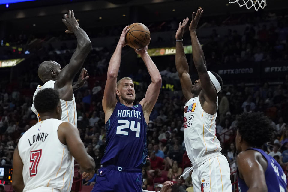 Charlotte Hornets center Mason Plumlee (24) drives to the basket as Miami Heat forward Jimmy Butler (22) defends during the first half of an NBA basketball game Thursday, Nov. 10, 2022, in Miami. (AP Photo/Marta Lavandier)