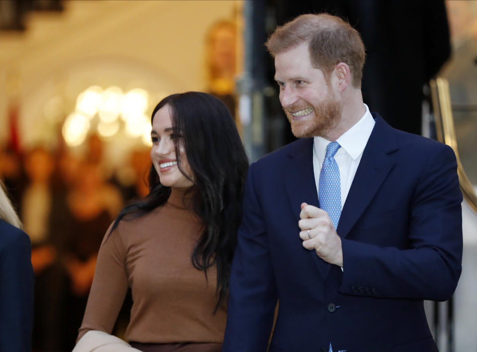 FILE - In this Tuesday Jan. 7, 2020 file photo Britain's Prince Harry and Meghan, Duchess of Sussex leave after visiting Canada House in London after their recent stay in Canada. In a stunning declaration, Britain's Prince Harry and his wife, Meghan, said they are planning "to step back" as senior members of the royal family and "work to become financially independent." A statement issued by the couple Wednesday, Jan. 8, 2020 also said they intend to "balance" their time between the U.K. and North America. (AP Photo/Frank Augstein, FILE)