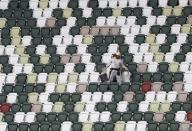 A worker is seen between spectators' seats at the construction site of the New National Stadium, the main stadium of Tokyo 2020 Olympics and Paralympics, during a media opportunity in Tokyo