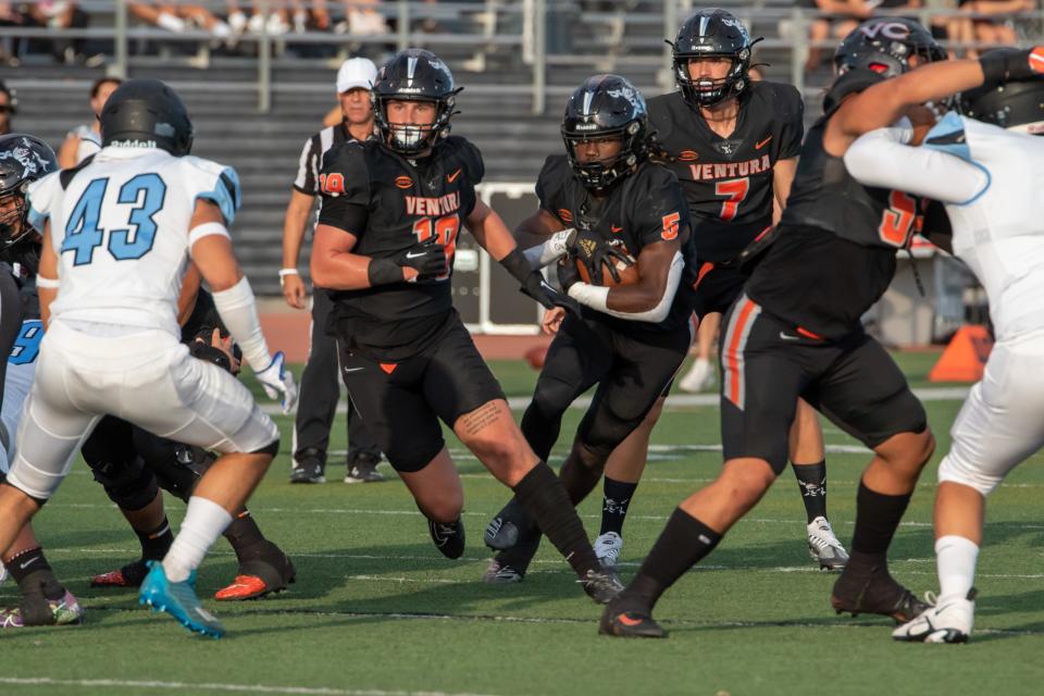 Ventura College running back JQ Brown runs through a hole in the 54th Citrus Cup game Saturday night at VC Sportsplex.