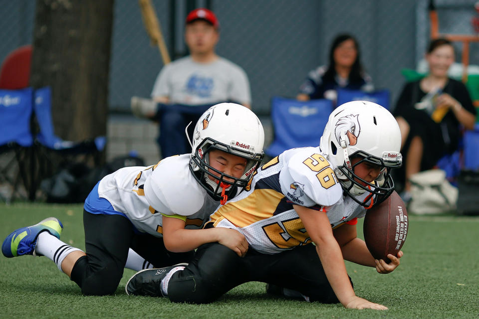 <p>Friends and relatives watch an Eagles training session of the Future League American football youth league team in Beijing, May 28, 2017. American football lags far behind soccer and basketball in China, but the huge potential market of 1.4 billion people has caught the attention of the NFL. (Photo: Thomas Peter/Reuters) </p>