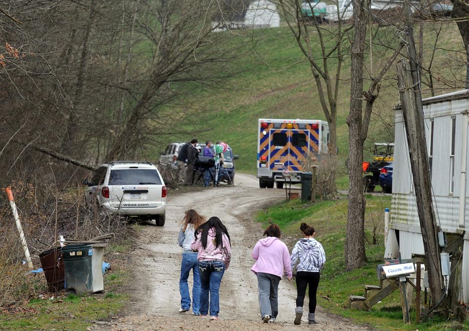 FILE - In this April 1, 2013 file photo, Friends and neighbors walk up and down the gravel road leading to Shain Gandee’s home in Sissonville, W.Va. Gandee, star of the MTV show “Buckwild”; his uncle, David Gandee; and Donald Robert Myers were found dead in the family’s Ford Bronco Monday morning. (AP Photo/The Charleston Gazette, Chip Ellis, File)