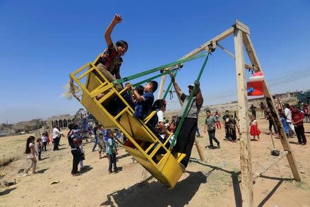 Iraqi children play as they celebrate Eid al-Fitr, in Mosul, Iraq June 25, 2017. REUTERS/Alaa Al-Marjani