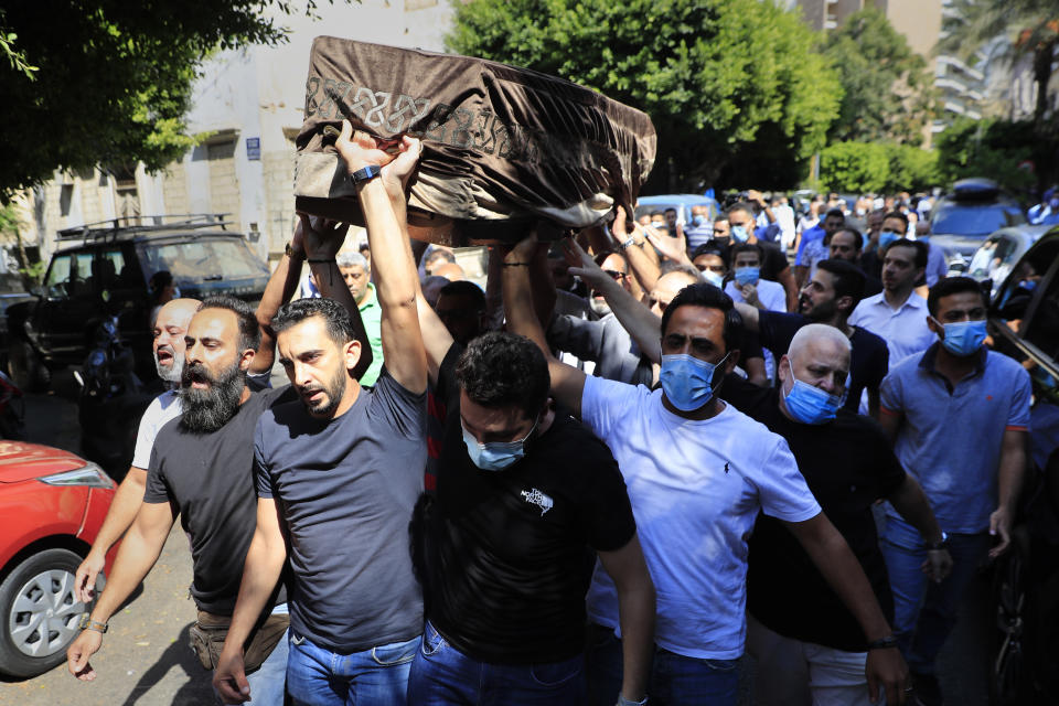 Mourners carry the coffin of Ibrahim Harb, 35, who was critically injured in the massive explosion at Beirut's port last year and who died on Monday nearly 14 months after the blast, during his funeral procession, in Beirut, Lebanon, Tuesday, Sept. 28, 2021. On Aug. 4, 2020, hundreds of tons of ammonium nitrate, a highly explosive material used in fertilizers, ignited after a massive fire at the port. The death brings to at least 215 the number of people who have been killed by the blast, according to official records. (AP Photo/Hussein Malla)