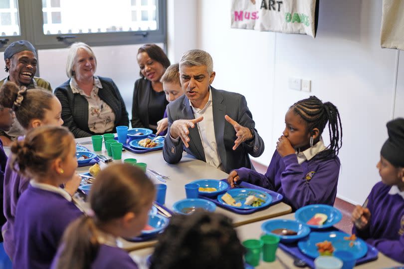 Mayor of London Sadiq Khan with children at a table during a visit to Torridon Primary School in south east London