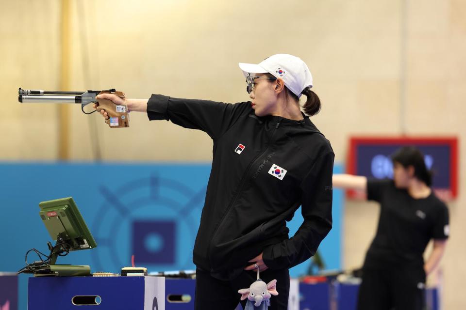 A woman points a gun.