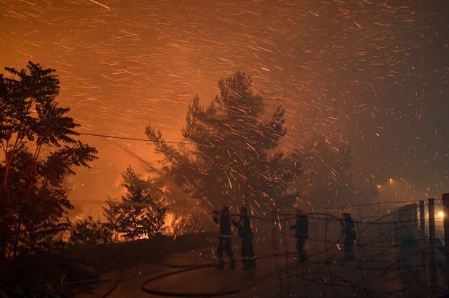 An Athens suburb is engulfed in flames during a wildfire. (Photo: Milos Bicanski via Getty Images)