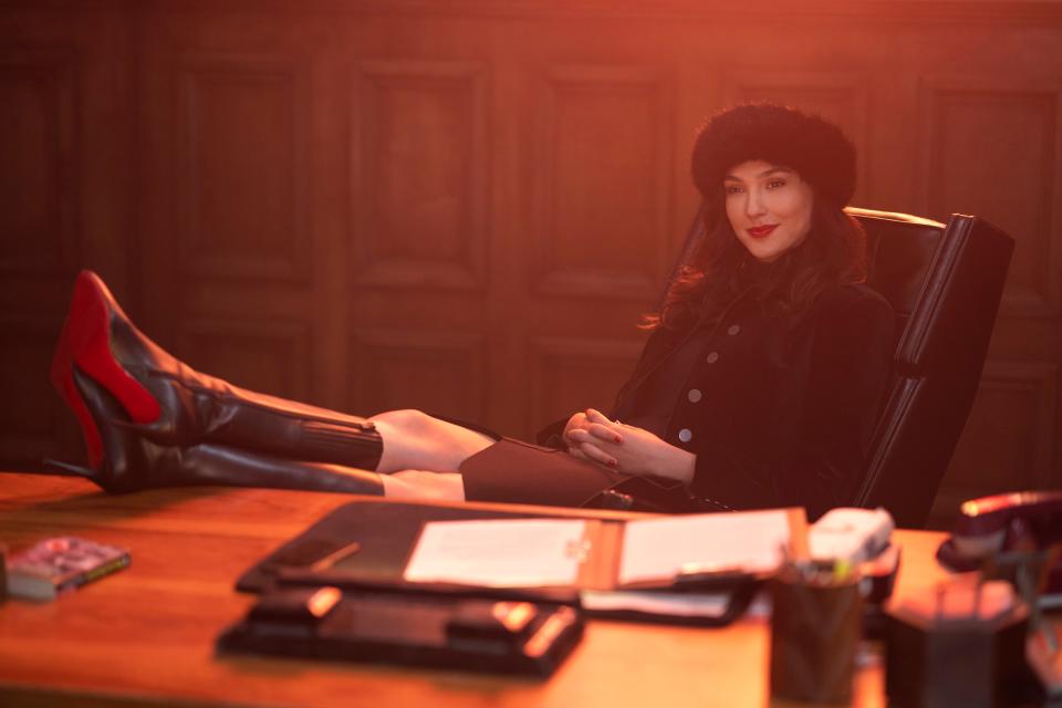 Gal Gadot sitting with her feet up on a desk