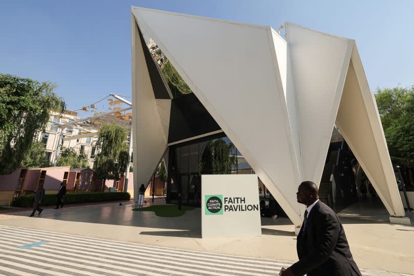 man walks in front of the Faith Pavilion at the venue of the COP28 United Nations climate summit in Dubai, December 2023