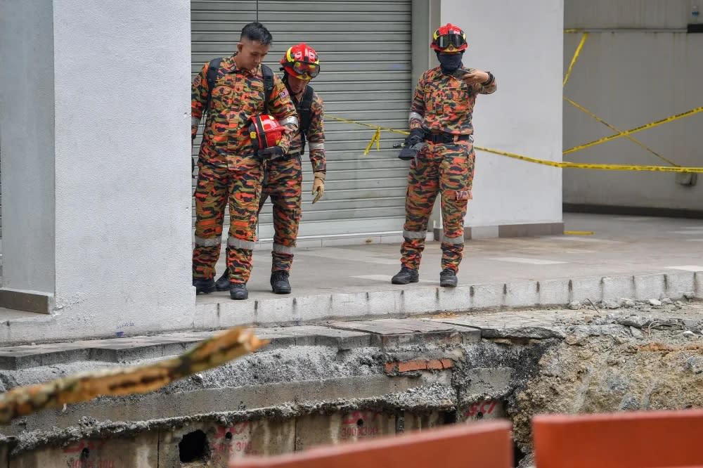 Rettungskräfte haben ihre Bemühungen verstärkt, die Frau zu finden, die in einem Erdloch in Kuala Lumpur verschwunden ist. (FOTO: Malay Mail)