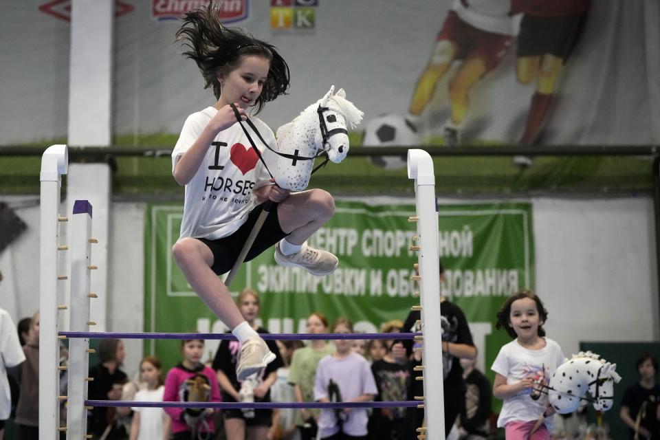 A girl competes during a Hobby horsing competition in St. Petersburg, Russia, on Sunday, April 21, 2024. Several dozen kids, 48 girls and one boy, from first-graders to teenagers gathered in a gymnasium in northern St. Petersburg, Russia's second largest city, for a hobby horsing competition. (AP Photo/Dmitri Lovetsky)