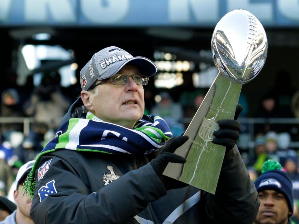 Paul Allen holds Super Bowl trophy while wearing Seattle Seahawks gear