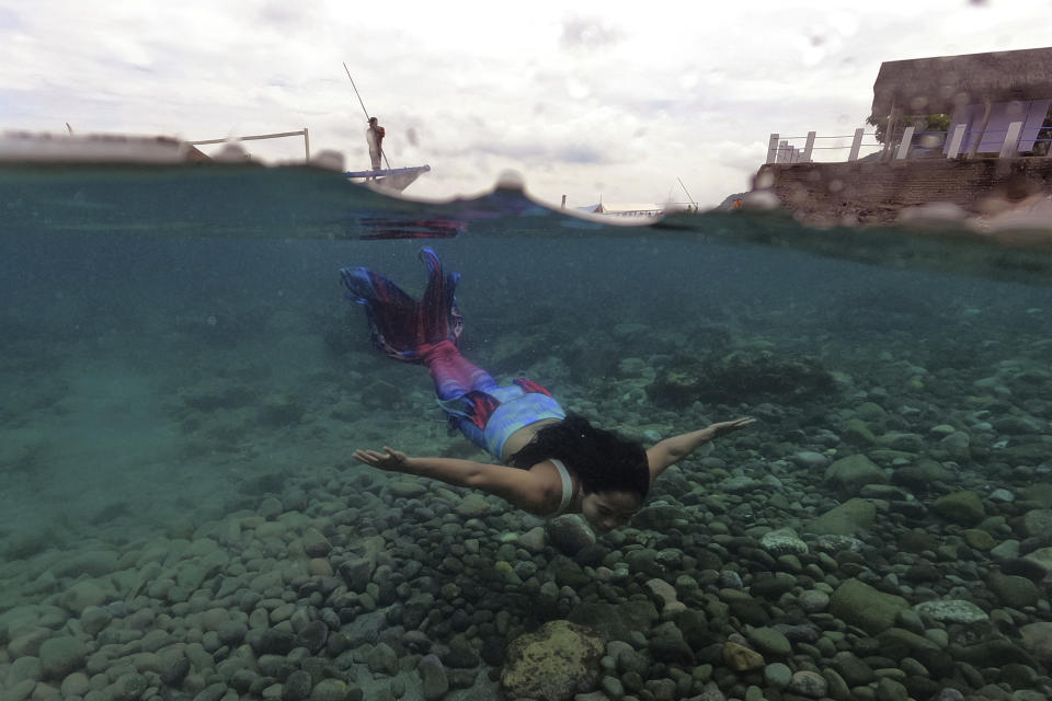 Jennica Secuya nada con un traje de sirena durante una clase de este tipo de natación en Mabini, en la provincia filipina de Batangas, el 22 de mayo de 2022. (AP Foto/Aaron Favila)