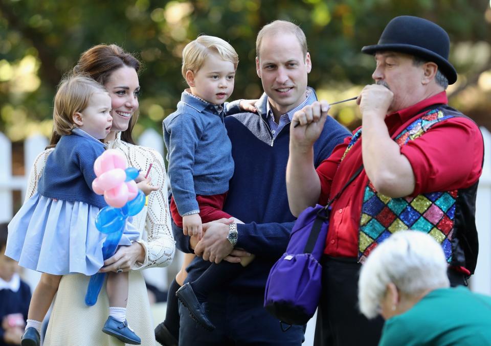 <p>The kids are captivated by a balloon artist. [Photo: Getty/Chris Jackson] </p>