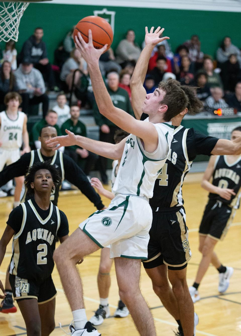 Central Catholic's Dylan Rouse goes to the hoop against St. Thomas Aquinas' Jaylen Jeter, left, and Julius Kimbrough in the second half, Saturday, Jan. 28, 2023.