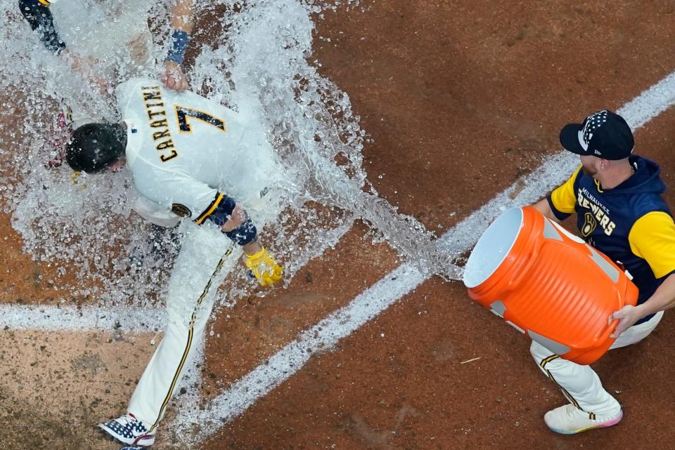 The Brewers' Victor Caratini gets a Gatorade bath courtesy of a teammate as he cross home plate after hitting a three-run walk-off home run against the Cubs in the bottom of the 10th inning Monday.