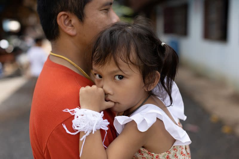 Tawatchai Supolwong holds his daugther Paveenut Supolwong, the only child survivor of the mass shooting in Uthai Sawan