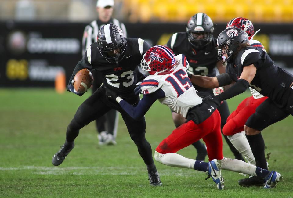 Aliquippa's Tiqwai Hayes (23) stiff arms McKeesport's Dominique Cochran (15) while sprinting downfield during the second half of the WPIAL 4A Championship game Friday evening at Acrisure Stadium in Pittsburgh, PA.