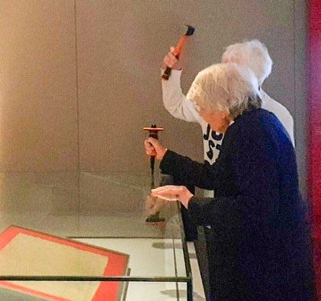Judy Bruce (hidden), 85, a retired biology teacher from Swansea and Reverend Sue Parfitt, 82, from Bristol, as they target the protective enclosure around the historic Magna Carta document with a hammer and chisel 