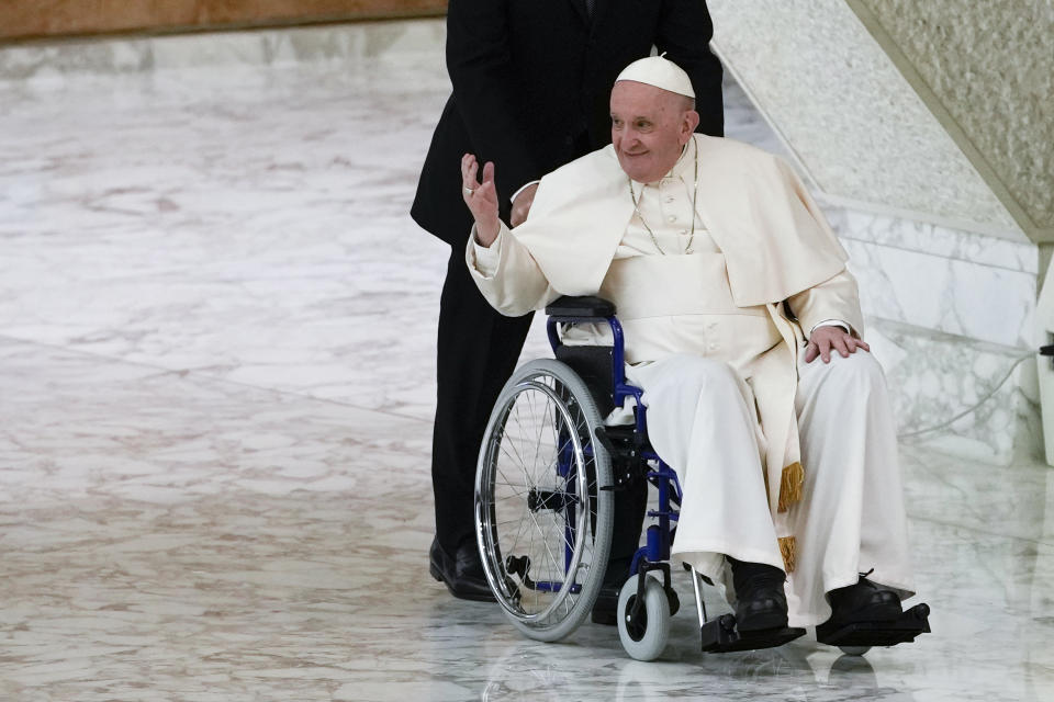 FILE - Pope Francis arrives in a wheelchair to attend an audience with nuns and religious superiors in the Paul VI Hall at The Vatican, Thursday, May 5, 2022. Pope Francis added fuel to rumors about the future of his pontificate on Saturday by announcing he would visit the central Italian city of L'Aquila in August for a feast initiated by Pope Celestine V, one of the few pontiffs who resigned before Pope Benedict XVI stepped down in 2013. (AP Photo/Alessandra Tarantino, File)