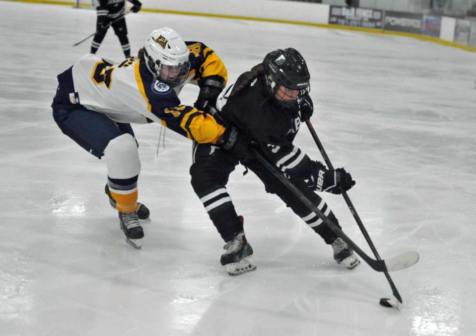 Notre Dame Academy's Lucy DelGallo, left, tries to steal the puck from Duxbury's McKenna Colella, right, during the Tenney Girls Winter Classic at The Bog in Kingston, Monday, Dec. 26, 2022.