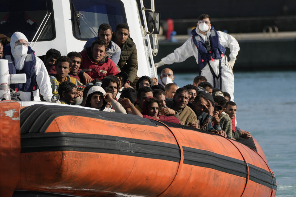Migrants and refugees enter in the port of Roccella Jonica, Calabria region, southern Italy, Sunday, Nov. 14, 2021. The Italian Coast Guard rescued Sunday morning off the cost Calabria over 250 young men and boys, mostly from Egypt. (AP Photo/Alessandra Tarantino)
