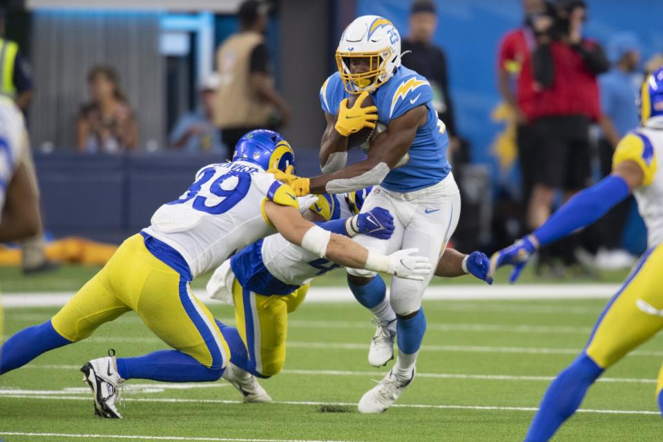 Chargers running back Joshua Kelley is tackled by Rams safety Jake Gervase.