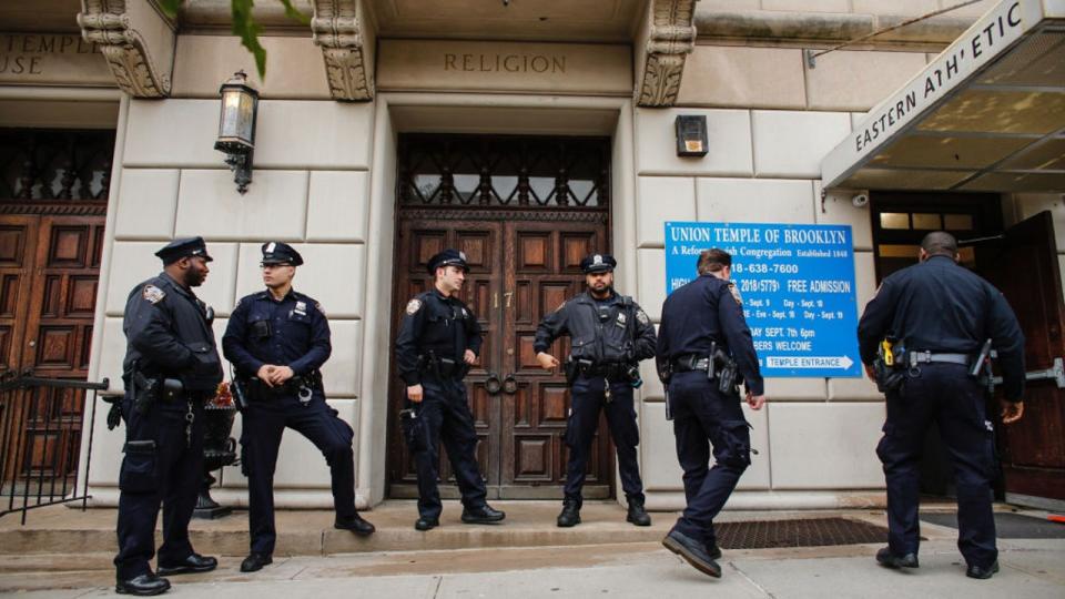 <div>FILE-NYPD officers stand guard at the door of the Union Temple of Brooklyn in New York City. (Photo credit-KENA BETANCUR/AFP via Getty Images)</div>