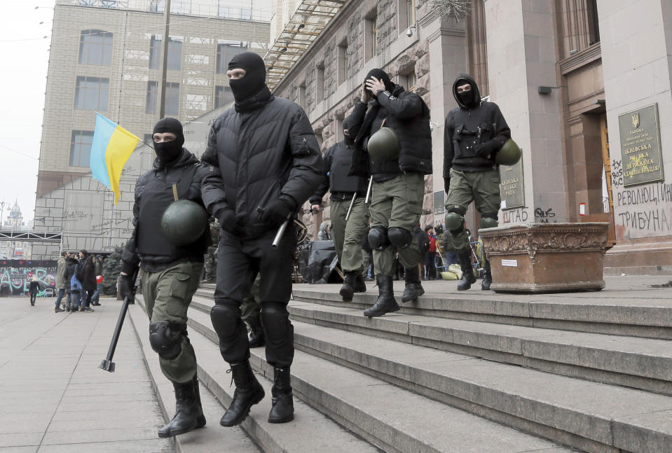 Opposition supporters leave Kiev City Hall in Kiev, Ukraine, Sunday, Feb. 16, 2014. Anti-government demonstrators in Ukraine's capital ended their nearly three-month occupation of Kiev City Hall on Sunday as promised in exchange for the release of all jailed protesters. But tensions remained high as hundreds stayed outside the building, vowing to retake it if the government fails to drop all criminal charges against the protesters.(AP Photo/Efrem Lukatsky)