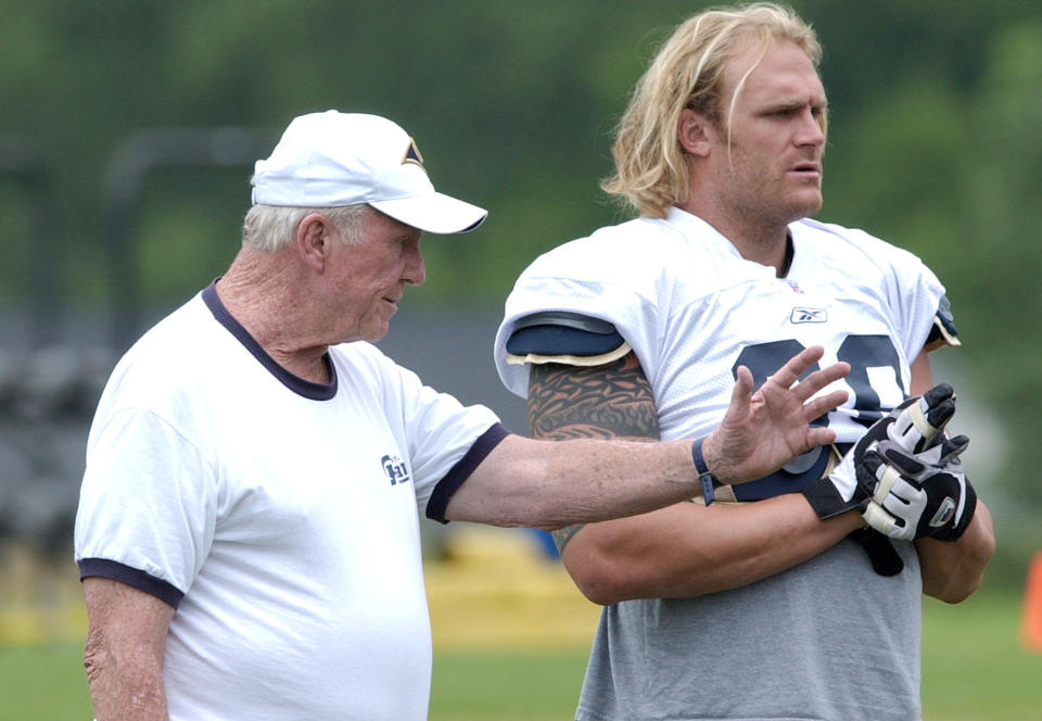 FILE - In this July 25, 2003, file photo, St. Louis Rams offensive line coach Jim Hanifan, left, works with Kyle Turley during NFL football training camp in Macomb, Ill. Hanifan, the former St. Louis Cardinals coach who returned to the city as offensive line coach to help the Rams win the Super Bowl, has died. He was 87. Hanifan’s daughter, Kathy Hinder, told the St. Louis Post-Dispatch that he died Tuesday, Nov. 23, 2020. She said the cause of death hasn't been determined, but said it wasn't related to COVID-19. (AP Photo/James A. Finley, File)