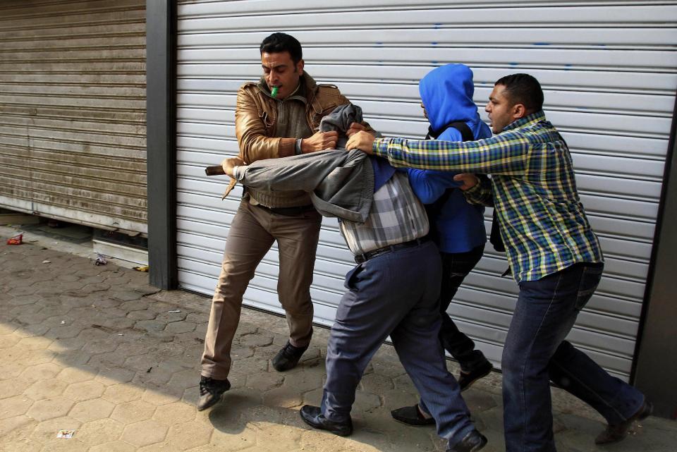 Egyptian plainclothes policemen arrest a supporter of Egypt’s ousted Islamist President Mohammed Morsi during clashes in Cairo, Egypt, Friday, Jan. 3, 2014. The confrontations spilled from main streets to side streets in heavily populated residential areas in several provinces including Cairo, Giza and Alexandria. Dozens of Muslim Brotherhood members and supporters hurled rocks at security forces, which responded with volleys of tear gas. (AP Photo/Ahmed Abd El Latif, El Shorouk newspaper) EGYPT OUT