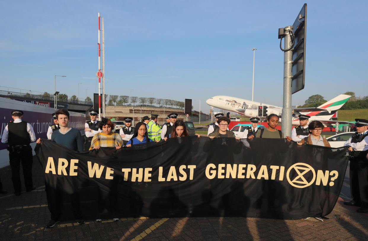 Climate change activists hold a banner as they attend an Extinction Rebellion protest outside Heathrow Airport in London, Britain April 19, 2019. REUTERS/Simon Dawson