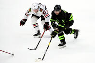 Dallas Stars defenseman Jamie Oleksiak (2) tries to skate around Chicago Blackhawks defenseman Adam Boqvist (27) in the second period of an NHL hockey game in Dallas, Thursday, March 11, 2021. (AP Photo/Matt Strasen)