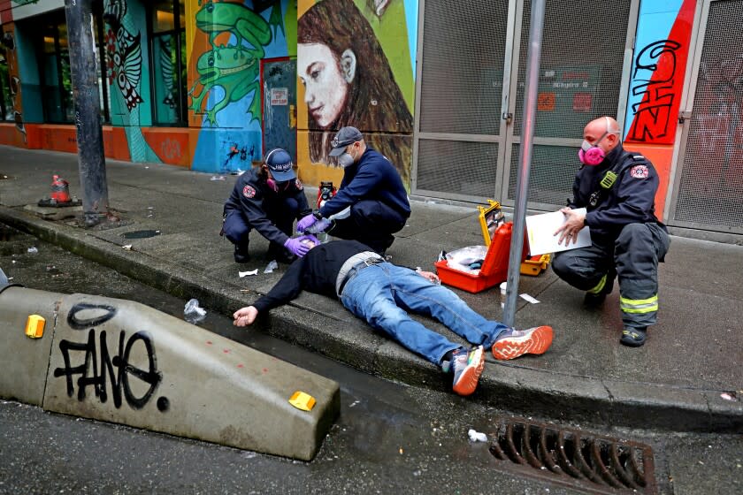 VANCOUVER, BRITISH COLUMBIA - MAY 05: Medics with the Vancouver Fire Rescue Services attend to a man who overdosed on drugs in the Downtown Eastside (DTES) neighborhood on Thursday, May 5, 2022 in Vancouver, British Columbia. A by stander witnessed the man collapse, then gave him two injections of Naloxone, a medicine that rapidly reverses an opioid overdose, and sent another person to get an oxygen tank from a supervised consumption site. Supervised consumption sites in the DTES give addicts who use fentanyl, opioids, crystal methamphetamine and other drugs a place to use and get harm reduction supplies; clean syringes, alcohol swabs, sterile water, tourniquets, spoons and filters. On April 14, 2016, provincial health officer Dr. Perry Kendall declared a public health emergency under the Public Health Act due to the significant rise in opioid-related overdose deaths reported in B.C. since the beginning of 2016. (Gary Coronado / Los Angeles Times)