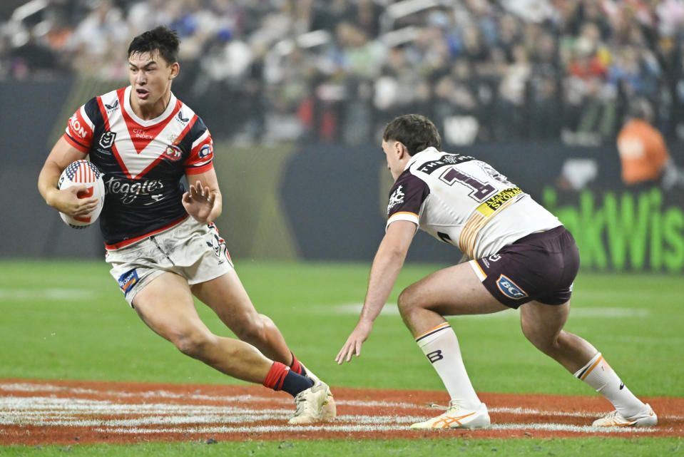 Roosters Joseph Manu, left, runs at the defense during the NRL match between the Sydney Roosters and the Brisbane Broncos at Allegiant Stadium in Las Vegas, Saturday, March 2, 2024. (AP Photo/David Becker)