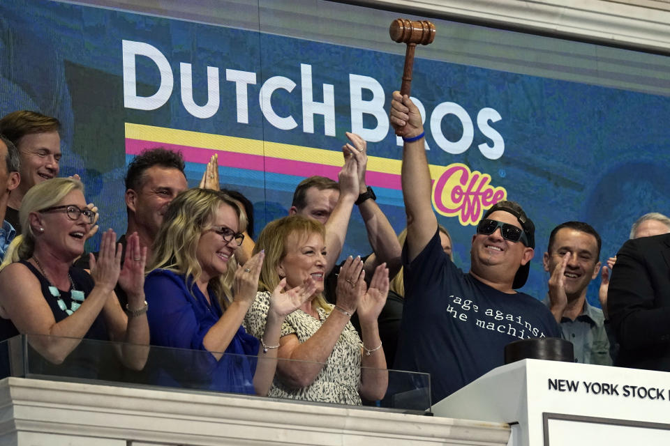 Dutch Bros Coffee Co-founder and Executive Chairman Travis Boersma, right, raises the gavel after ringing the New York Stock Exchange closing bell, Wednesday, Sept. 15, 2021. (AP Photo/Richard Drew)