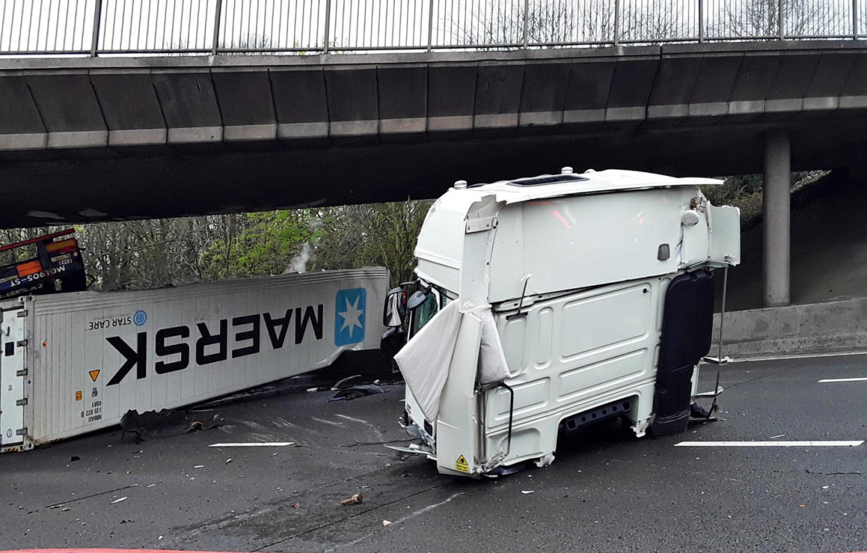 Dramatic photographs show the aftermath of a horror motorway crash which has left a lorry split in half. See SWNS story SWLNcrash; Emergency services were called to the M6 in Staffordshire following the smash involving a lorry which overturned and caught fire earlier today (Sun).  Traffic was stopped in both directions between Junction 12 for Cannock and Junction 13 for Stafford as police and ambulance crews rushed to the scene. Shocking images show how the HGV was completely split in two by the impact of the collision which also left its engine strewn across the carriageway. 